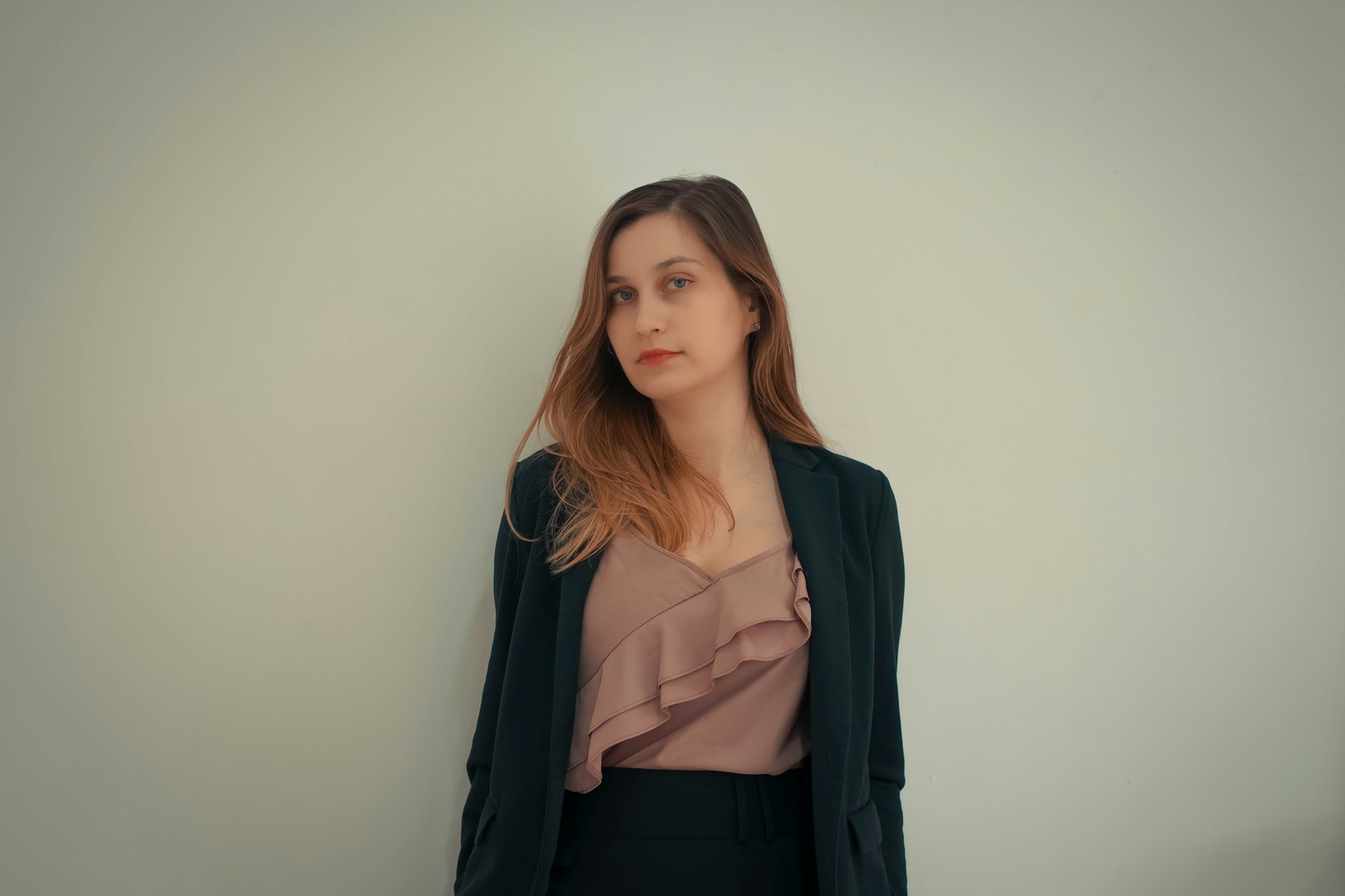 a woman standing in front of a white wall